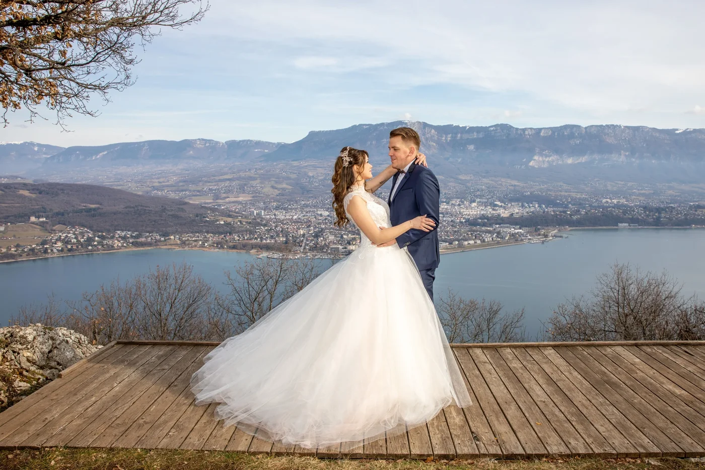 Mariés enlacés sur une terrasse dominant le lac et les montagnes — séance couple mariage