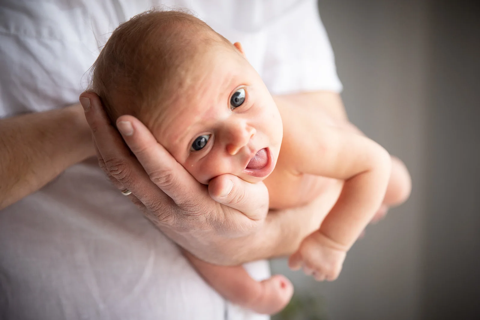 Nouveau-né souriant dans les bras de sa maman