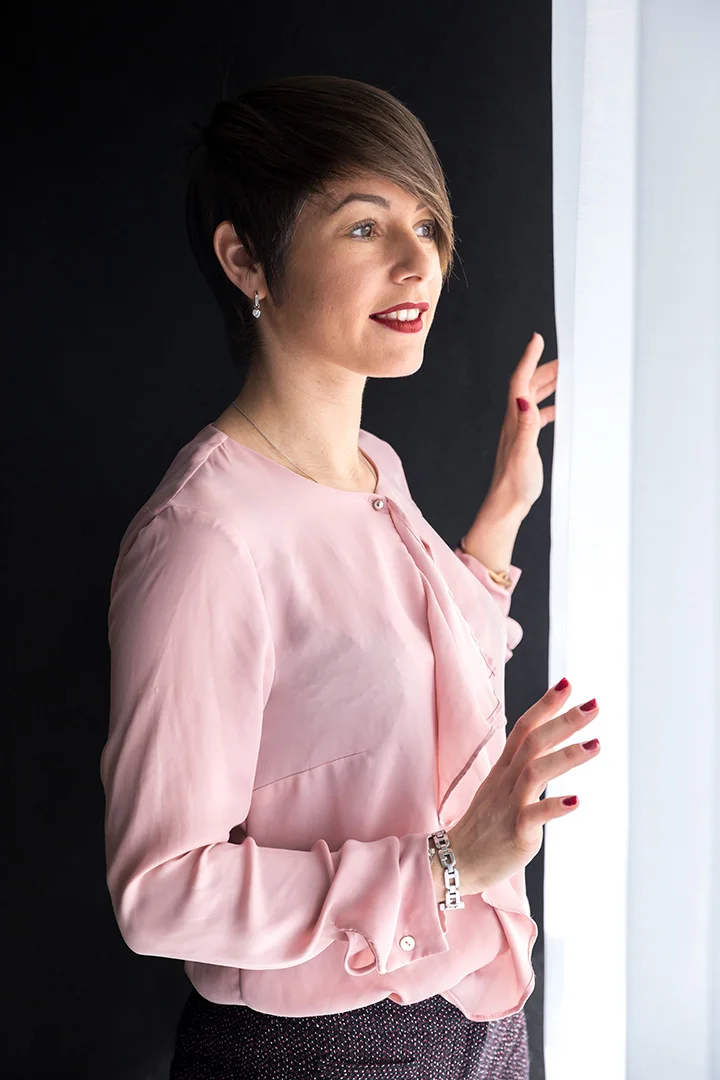 Portrait de femme en blouse rose près d'une fenêtre, lumière naturelle — Partenaire Image